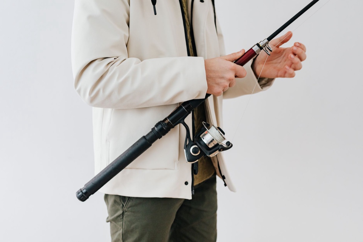Conjunto de vara e carretilha de pesca.