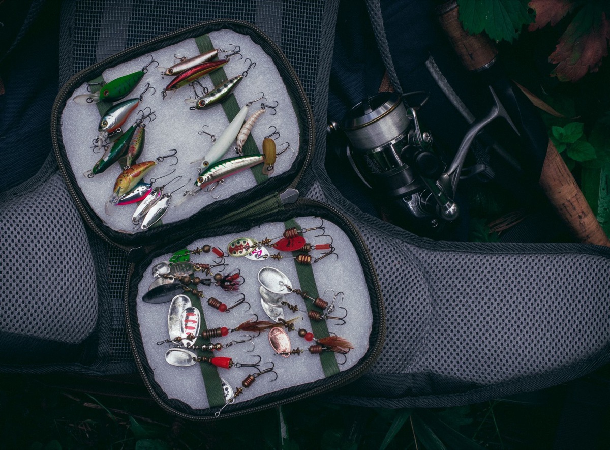 Caixa de acessórios de pesca com diversos itens essenciais.