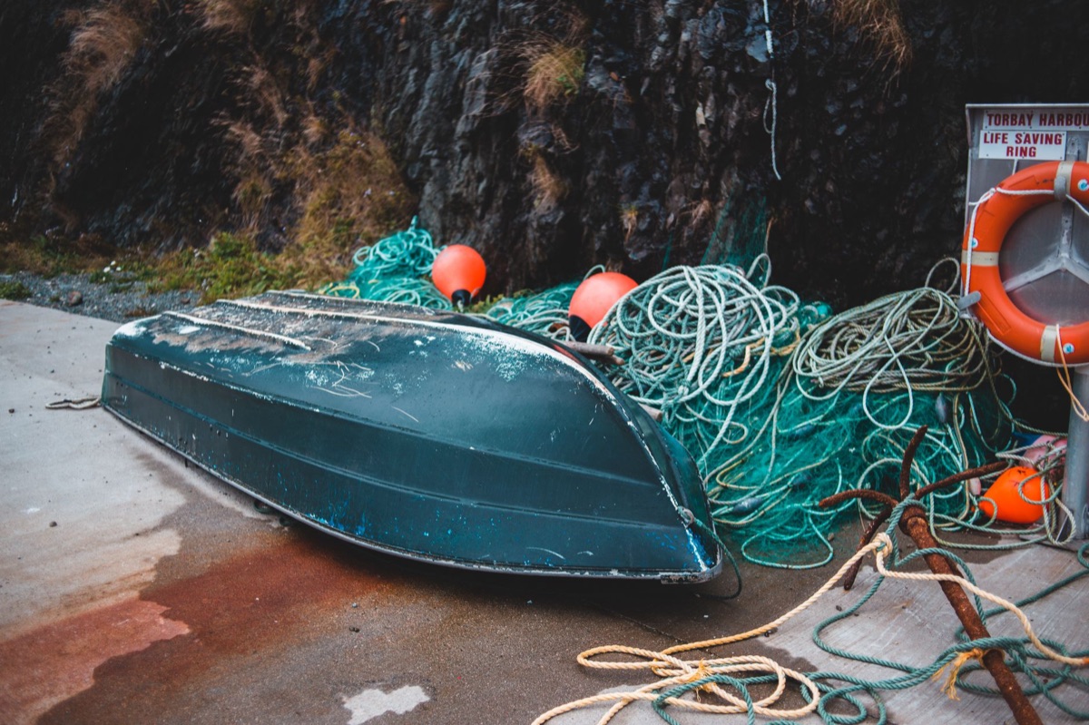 barco de pesca com rede e caixa de equipamentos