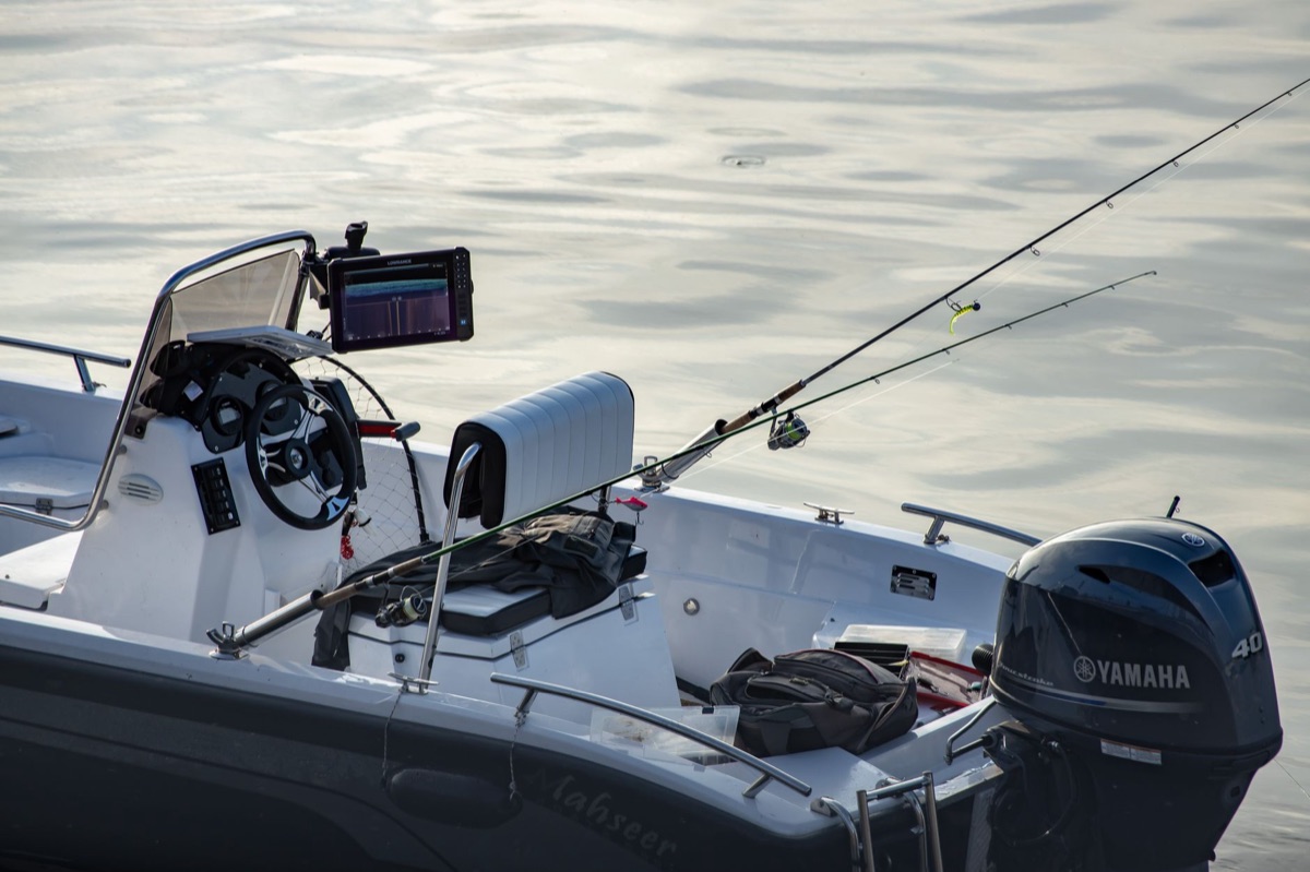 A stainless steel rod holder mounted on the deck of a fishing boat.