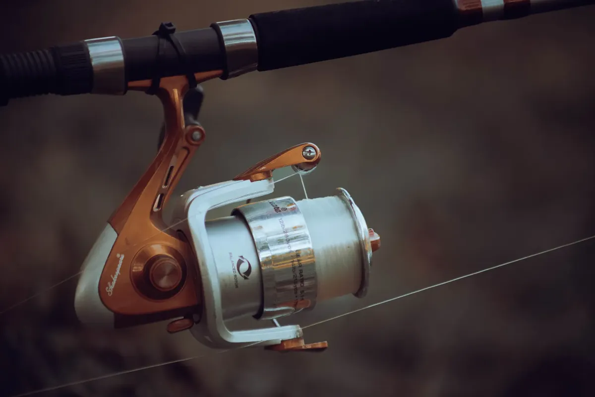Detailed view of a fishing reel with line tension, showcasing precise fishing equipment mechanics.
