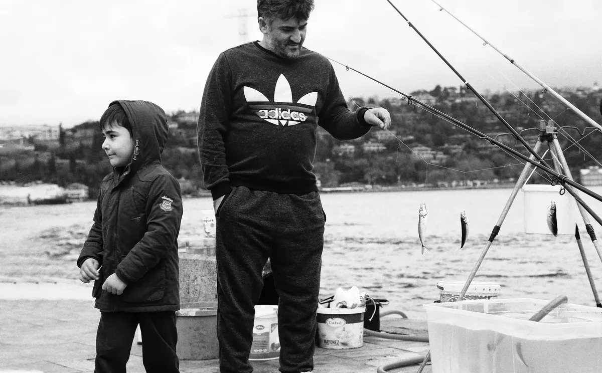 男と男の子が海辺で釣りに出かけ、モノクロで捉えた時間の瞬間。